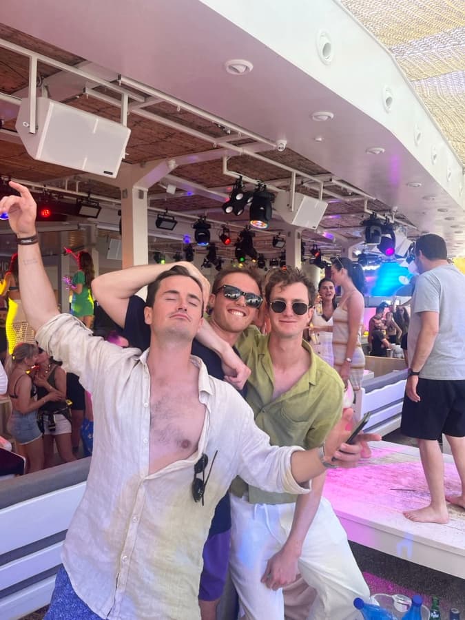 Photo: three friends at a daytime beach club party